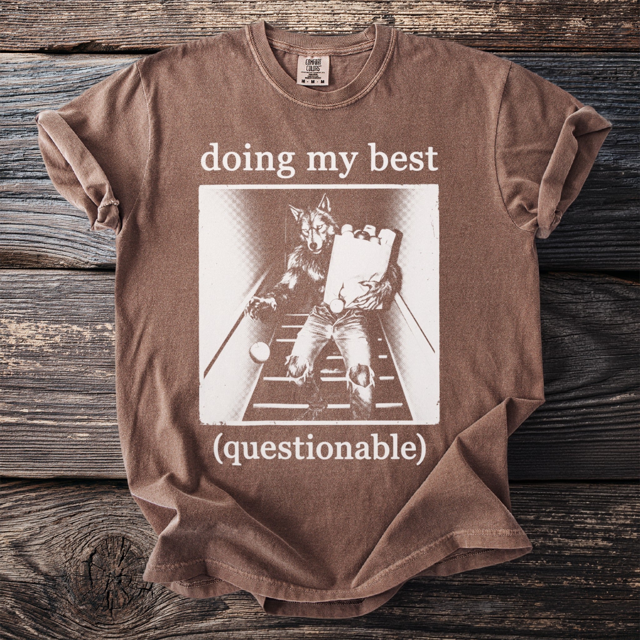 Brown t-shirt with white text "doing my best (questionable)" and werewolf graphic.