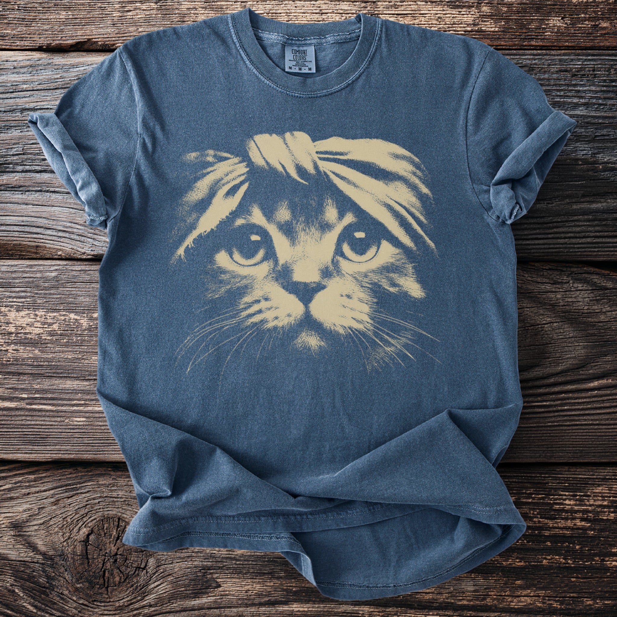 Blue t-shirt with a tan graphic of a cat wearing a headband.