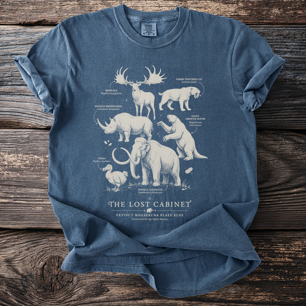 Extinct megafauna illustrated on a blue t-shirt with labels: Irish Elk, Saber-Toothed Cat, Dodo.