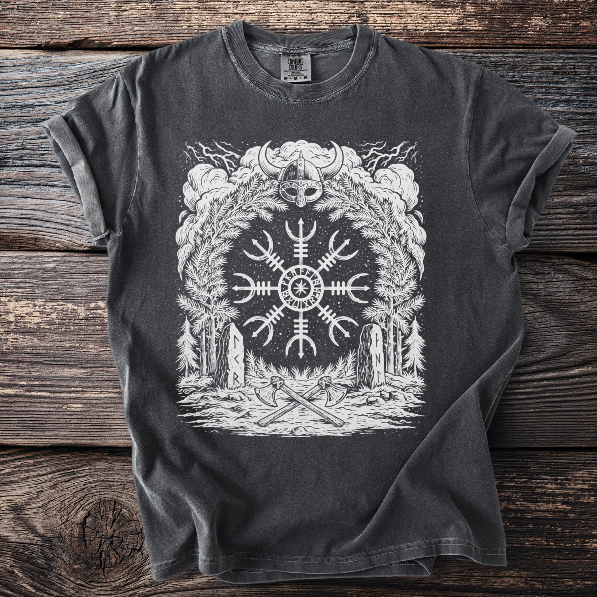 Dark t-shirt with white Viking helm, Vegvisir symbol, axes, and forest scene.