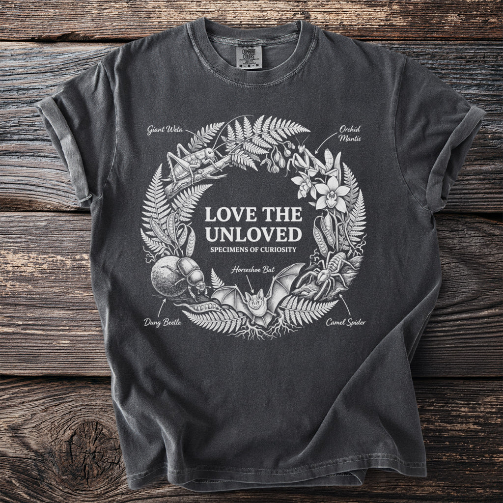 Dark t-shirt with wreath of insects and plants, text "LOVE THE UNLOVED".