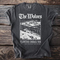 T-shirt with graphic of wolves walking across a snowy mountain landscape and text "The Wolves Yellowstone Comeback Tour".