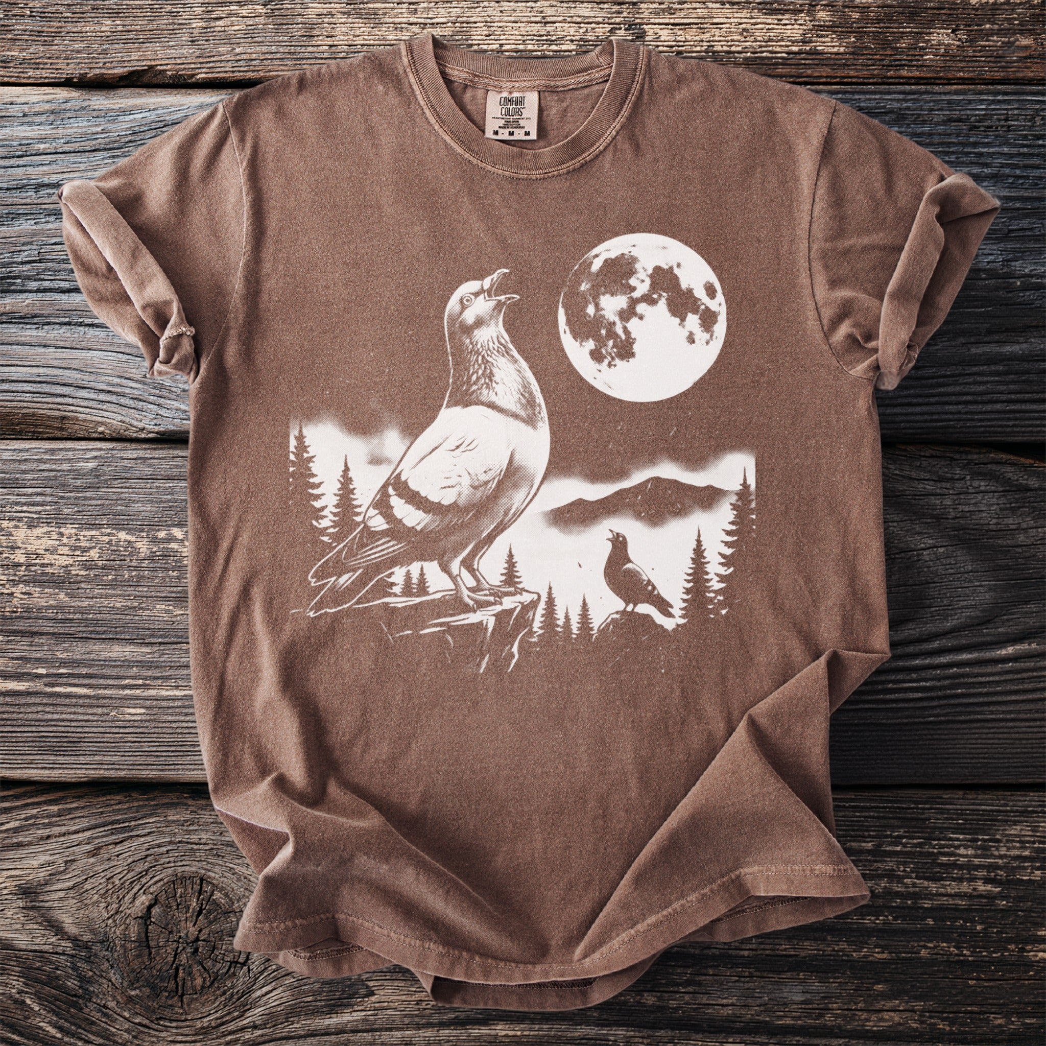 Brown t-shirt featuring a graphic of two pigeons and a moon.