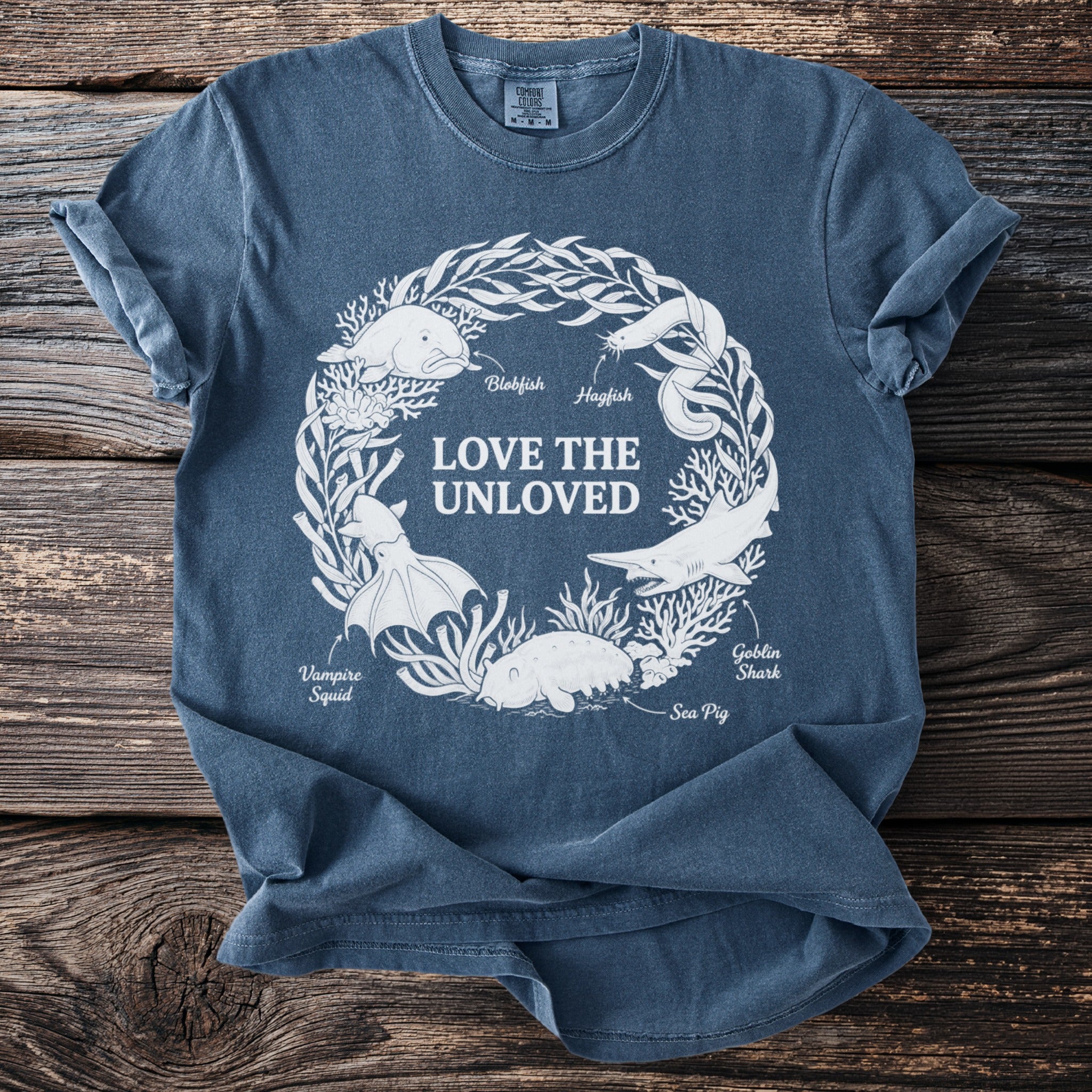 Blue t-shirt with "Love the Unloved" text and marine life illustrations.
