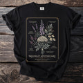 Black t-shirt with botanical illustration and "Moonlit Apothecary Herbarium Plate I" text.