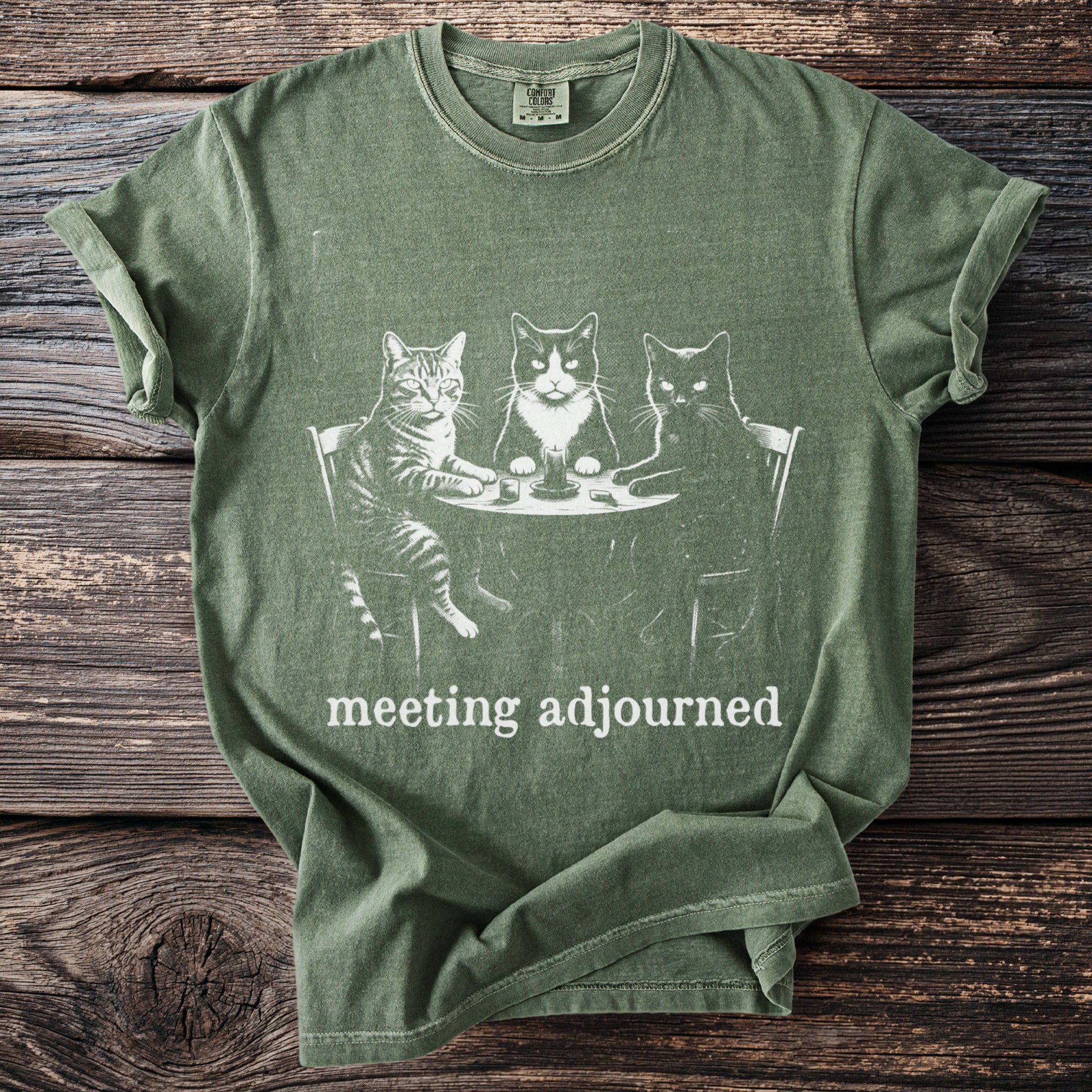 Green t-shirt with three cats at a table, text "meeting adjourned".