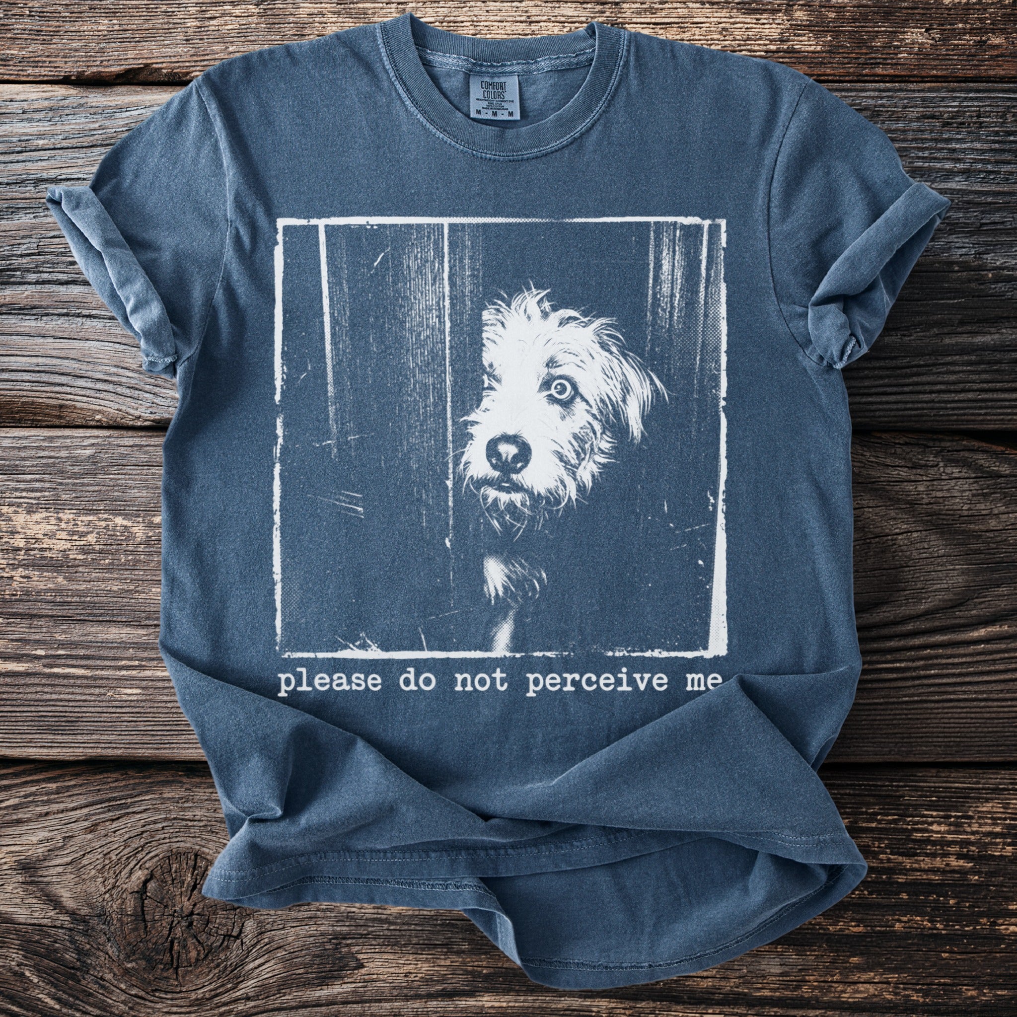 Blue t-shirt with a distressed graphic of a dog peeking through a gap and text.