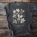 Dark gray t-shirt with botanical illustrations of trees and text "GIFTS OF THE OLD WOOD".