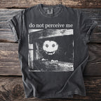 Dark gray T shirt with a bushbaby peering through wooden planks and “do not perceive me” text.
