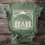 Green t-shirt with graphic of cloaked figures around a bonfire under a large sun.