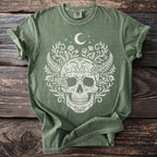 Green t-shirt with a white skull, moon, stars, floral, and moth design.