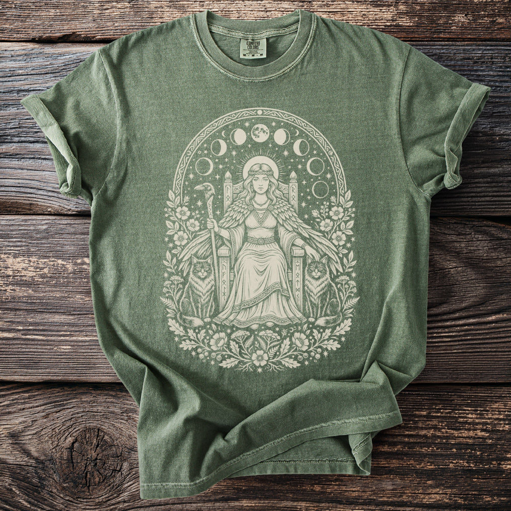 Green t-shirt with a light cream graphic of a seated queen, moon phases, and cats.