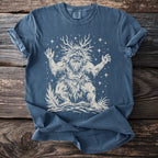 Blue t-shirt with a cream graphic of a creature with antlers and stars.