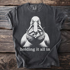 T-shirt with black and white graphic of a pelican with fish, and text "holding it all in."