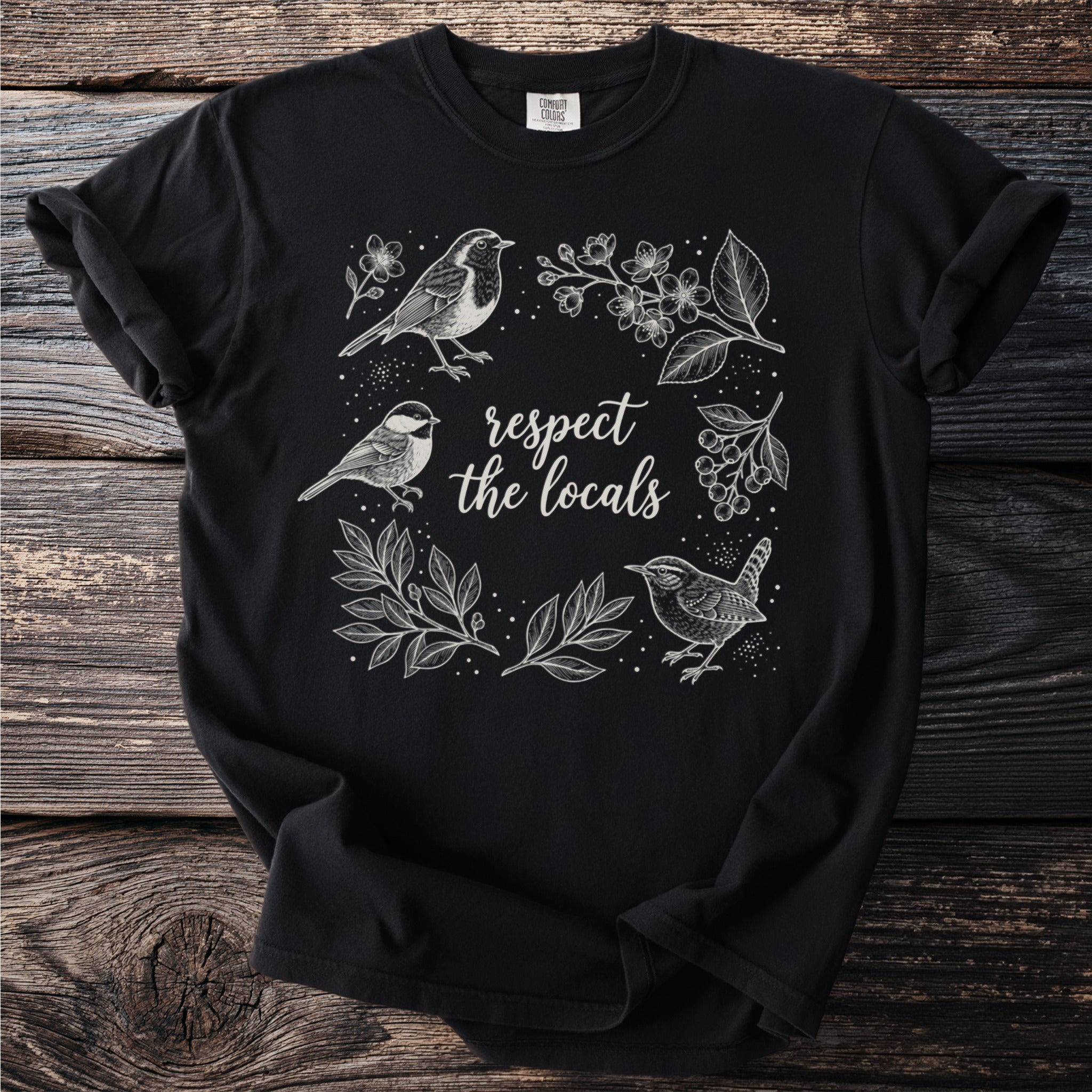 Black t-shirt with a white line drawing of birds and foliage, reading "respect the locals".