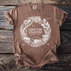 Brown t-shirt with white line art of unusual animals and "Love The Unloved" text.
