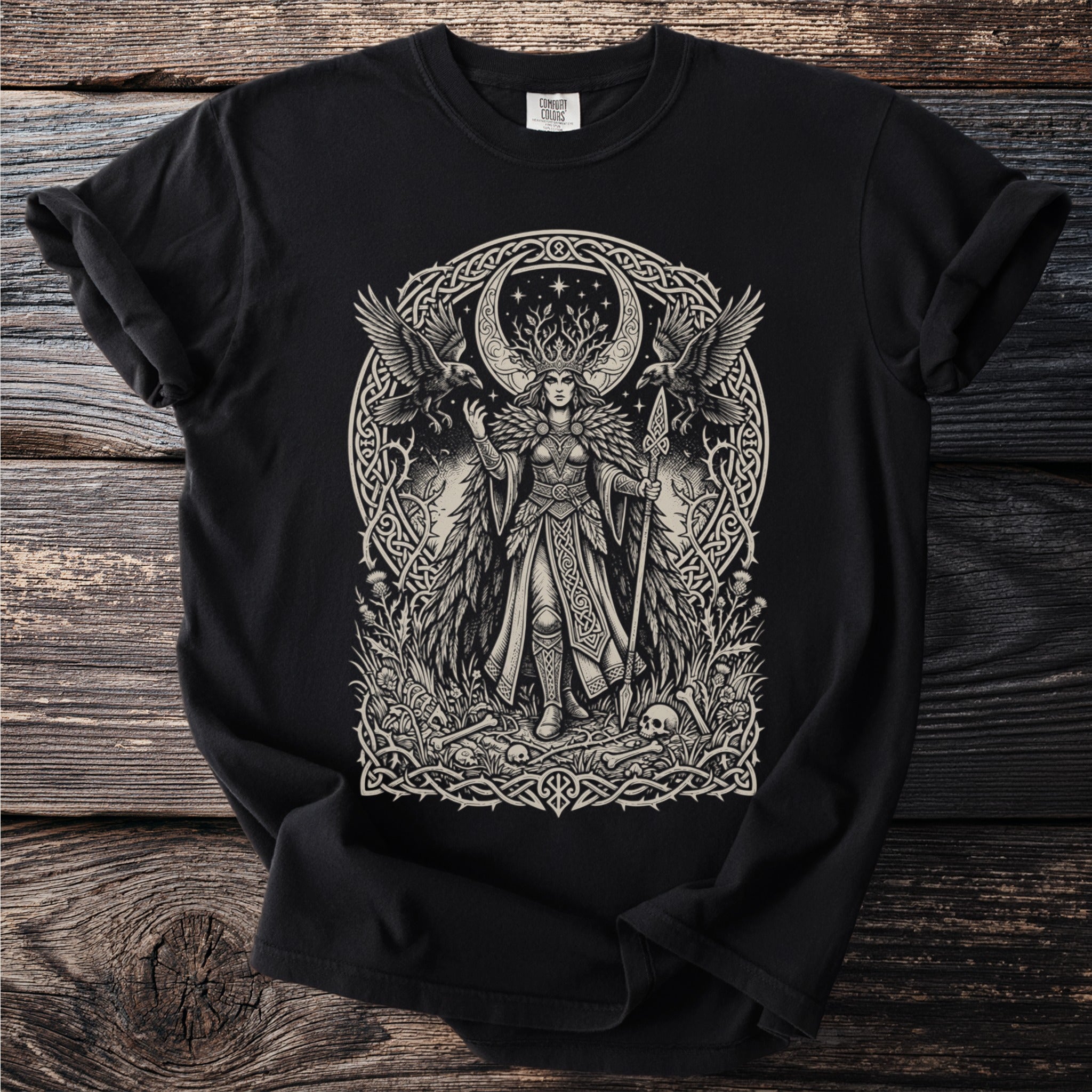 Black t-shirt with a detailed illustration of a crowned woman with wings surrounded by ravens and Celtic knotwork.