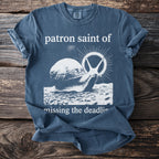 Blue t-shirt with graphic of snail and text "patron saint of missing the deadline".