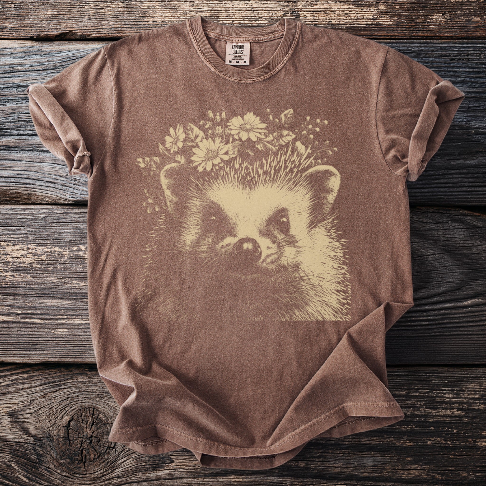 Brown t-shirt with a graphic of a hedgehog wearing a flower crown.