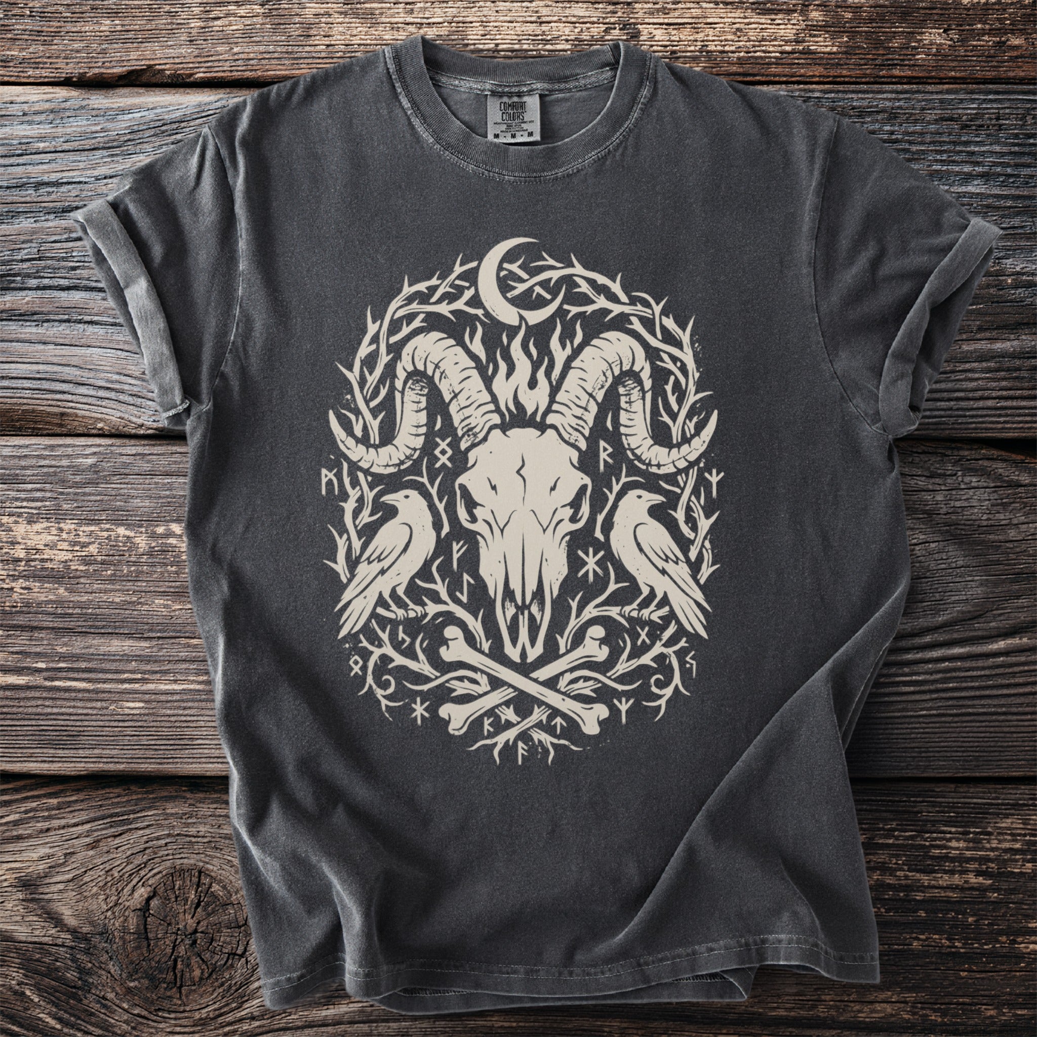 Dark grey t-shirt with a distressed graphic of a ram skull, two ravens, bones, and runes.