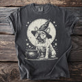 French bulldog wearing a witch hat next to a cauldron with stars and moon.