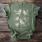 Green t-shirt featuring detailed ornithological illustrations of six songbirds and text.