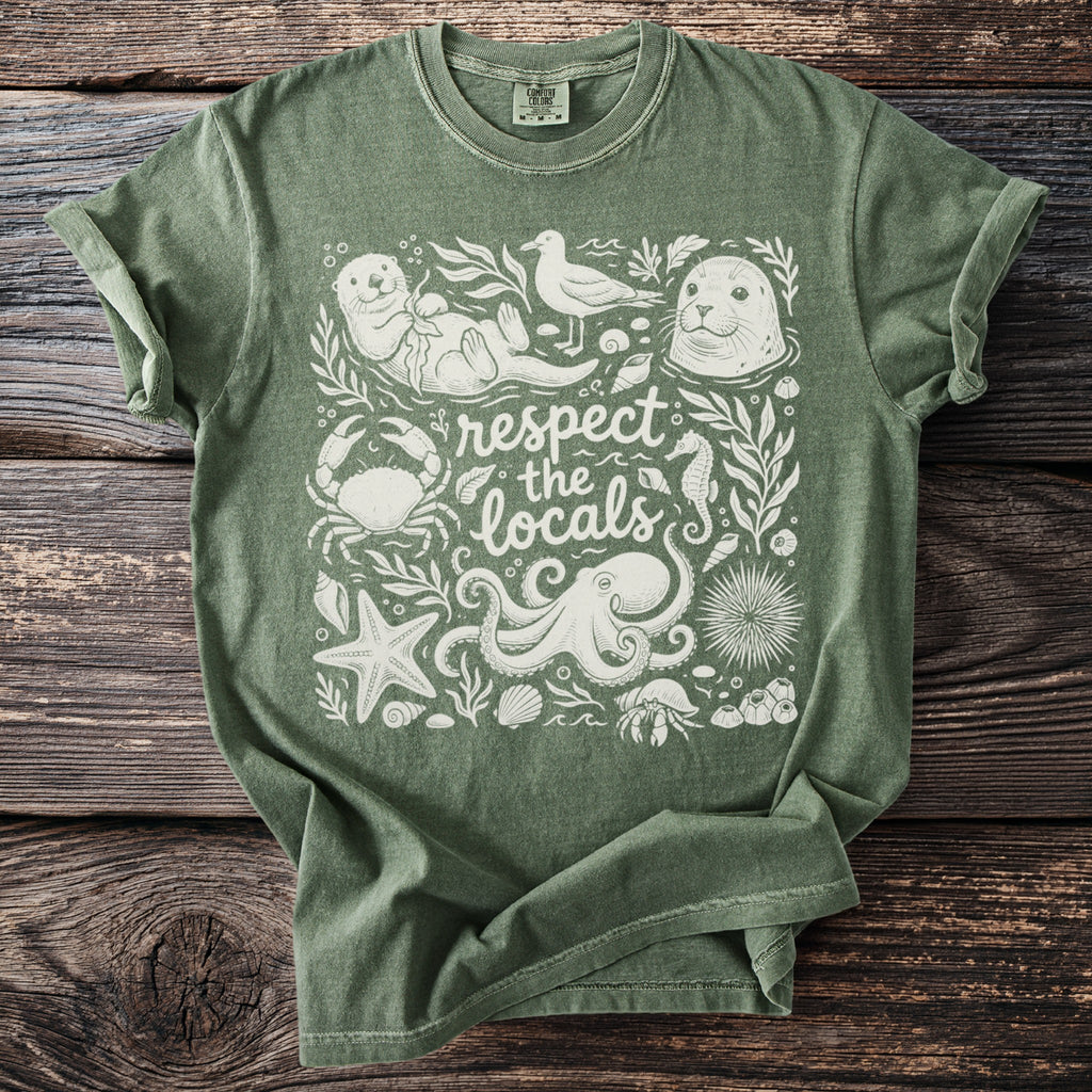 Green t-shirt with a white graphic of marine animals and the text "respect the locals".