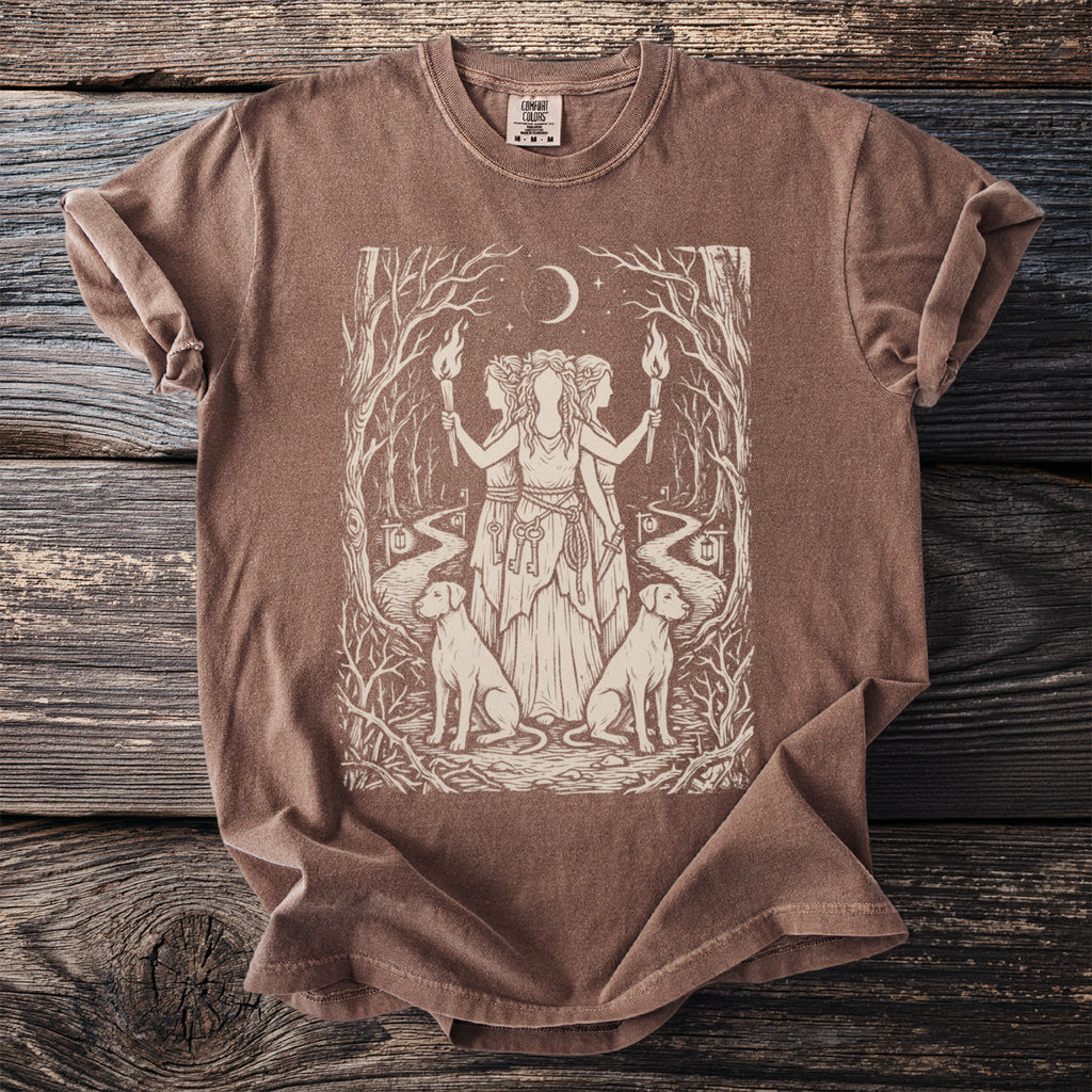 Brown t-shirt with a screen print of a forest scene featuring three figures, dogs, and keys.