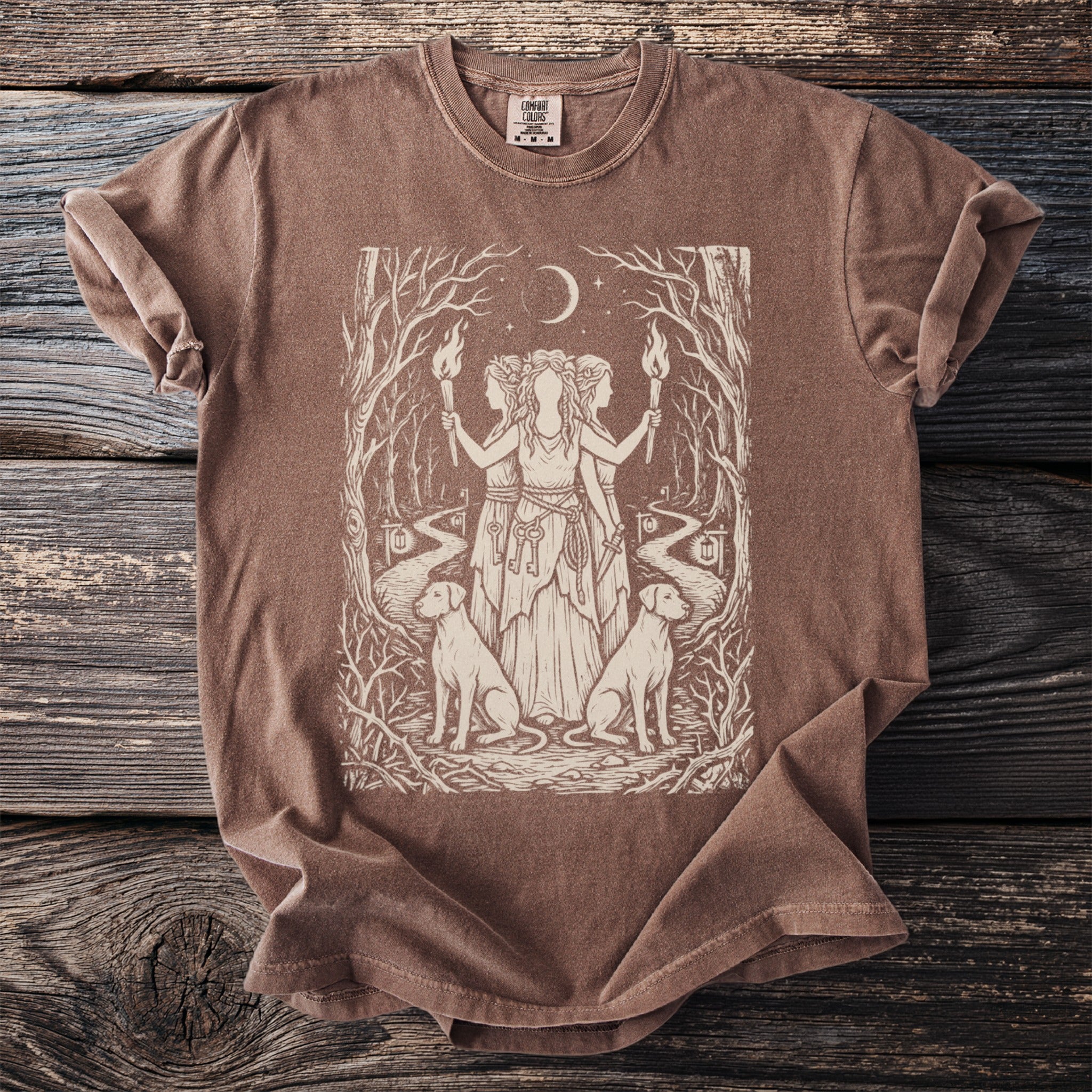 Brown t-shirt with a screen print of a forest scene featuring three figures, dogs, and keys.