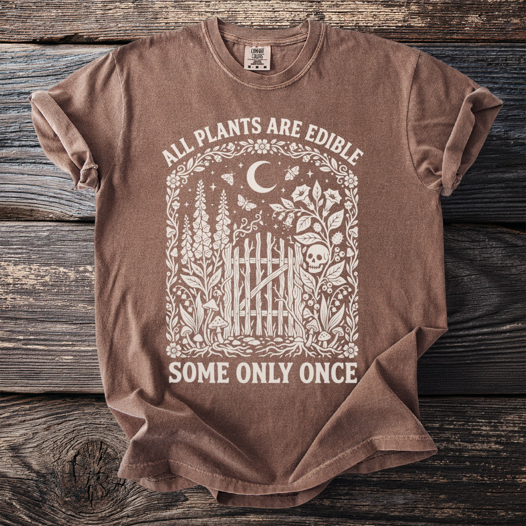 Brown Comfort Colors t-shirt with "ALL PLANTS ARE EDIBLE SOME ONLY ONCE" text and floral skull design.