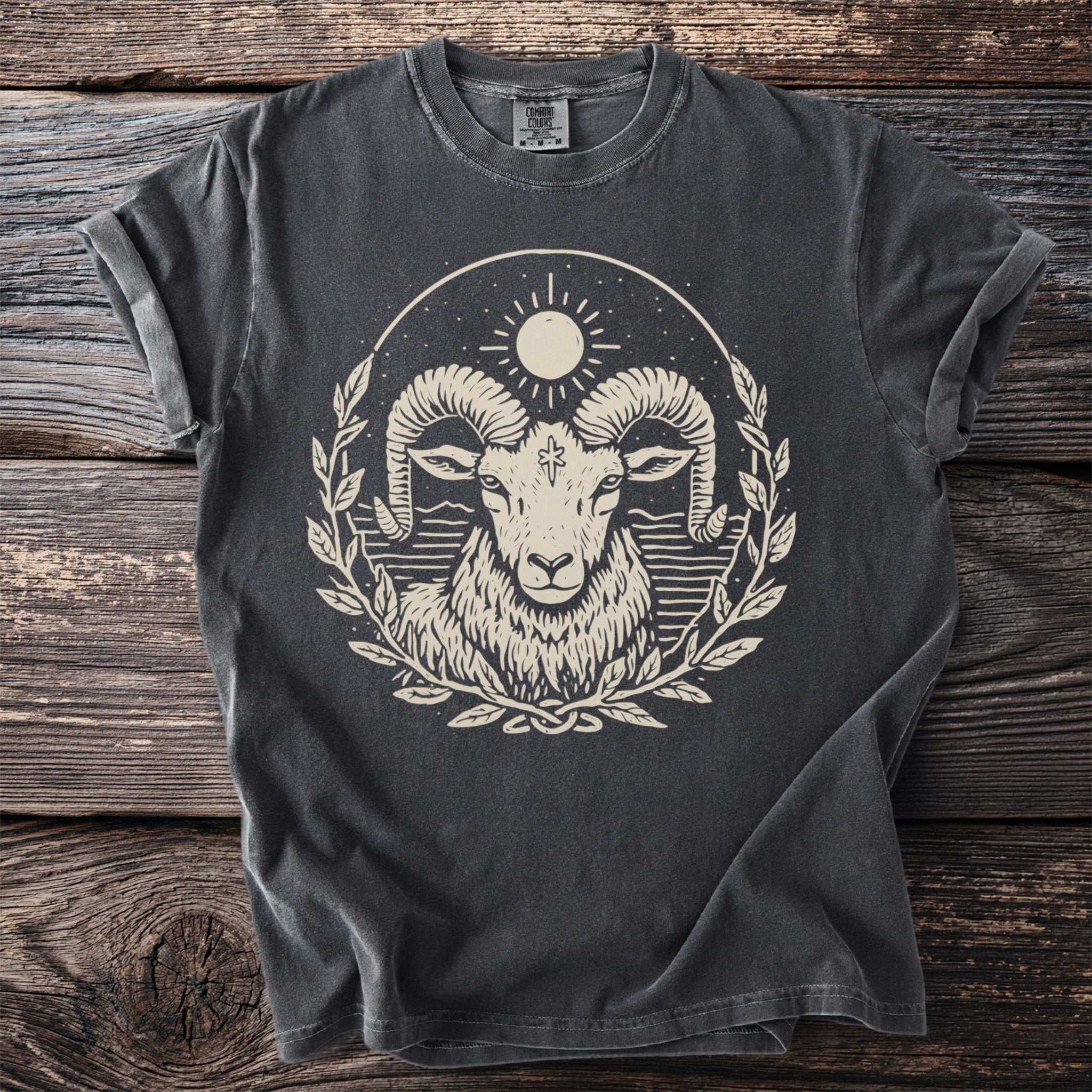 Dark t-shirt with a cream graphic of a ram's head within a laurel wreath.