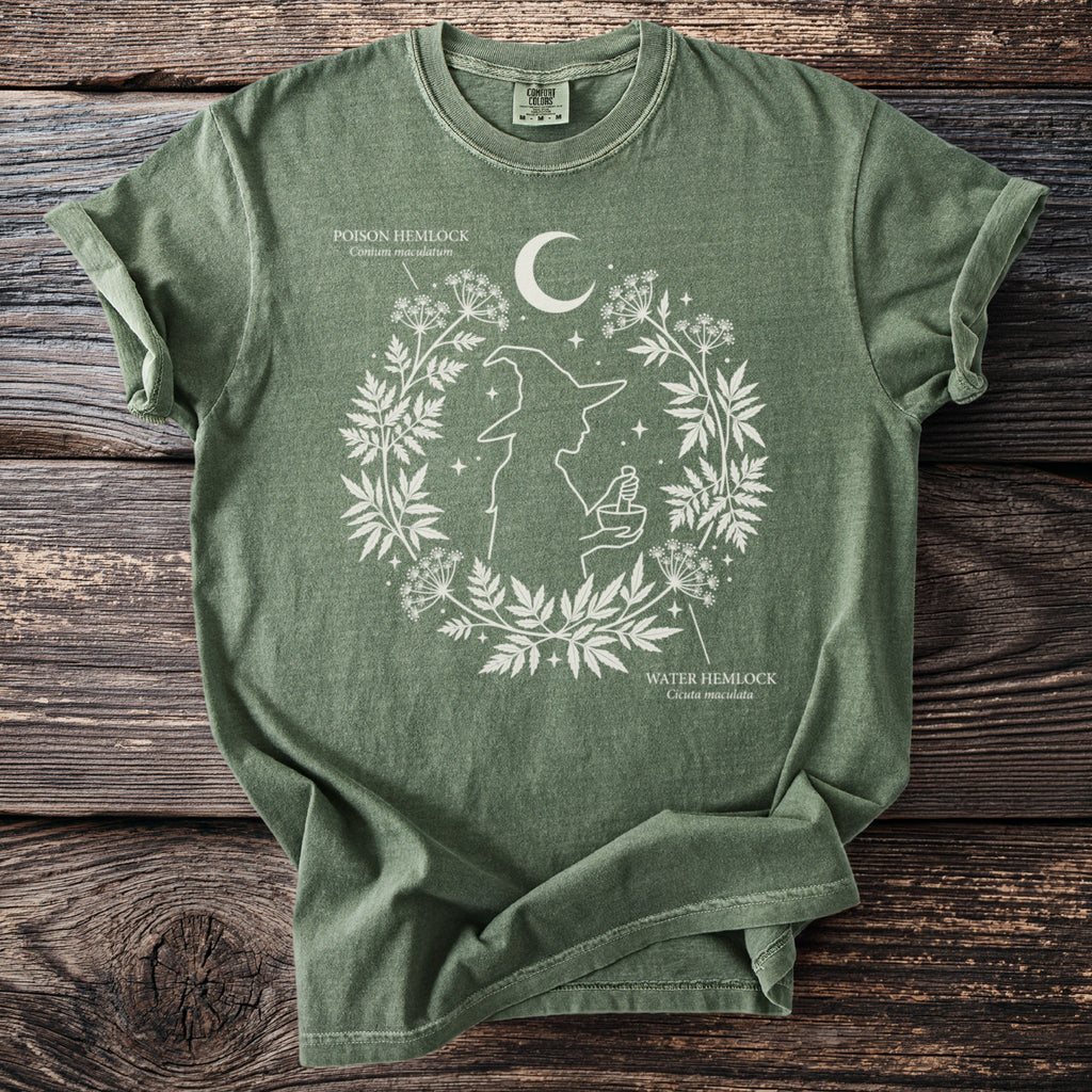 Green t-shirt with white witch and botanical print featuring poison and water hemlock.