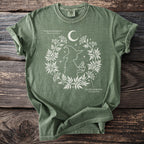 Green t-shirt with white witch and botanical print featuring poison and water hemlock.