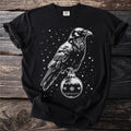 Black t-shirt with white ink print of a raven perched on an ornament.