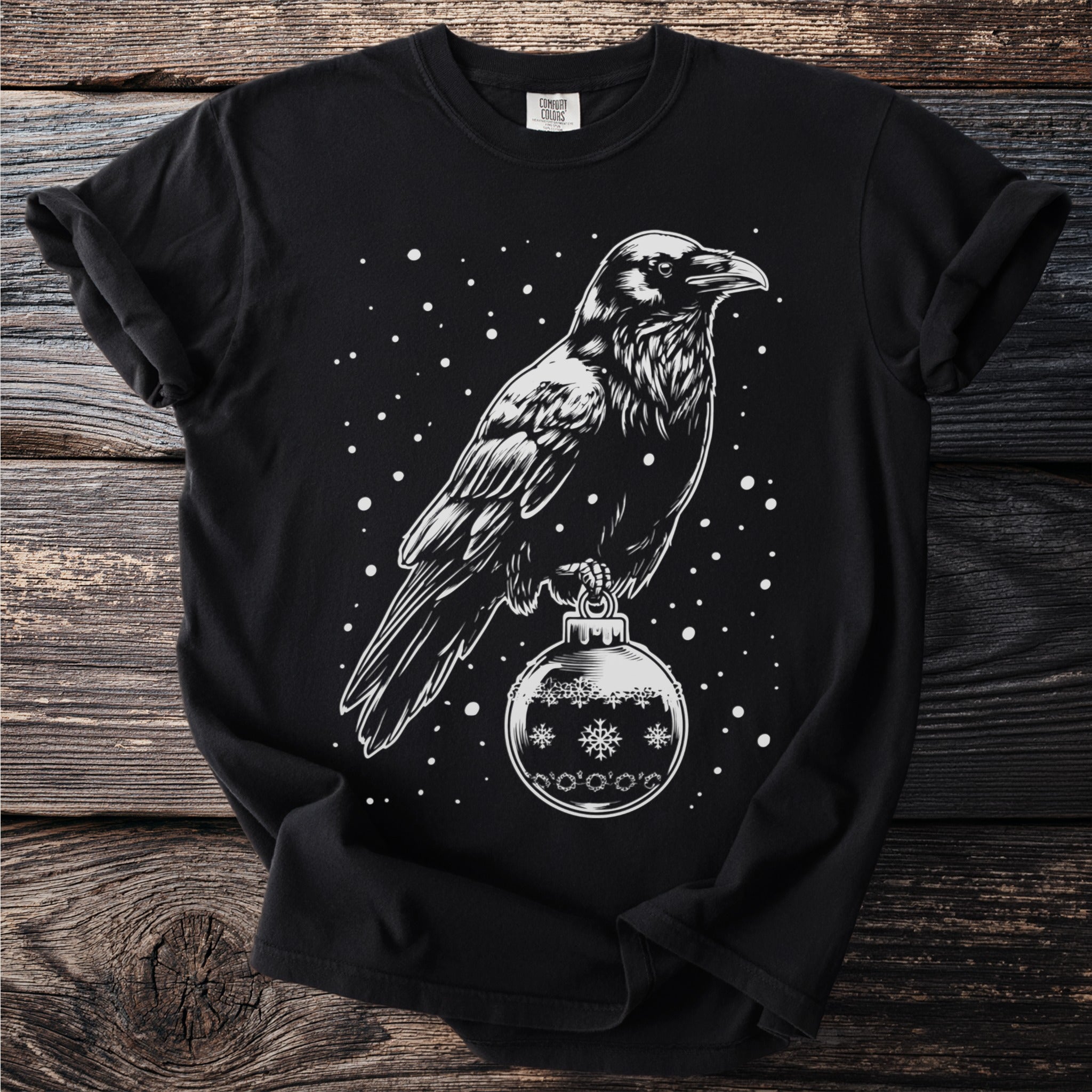 Black t-shirt with white ink print of a raven perched on an ornament.