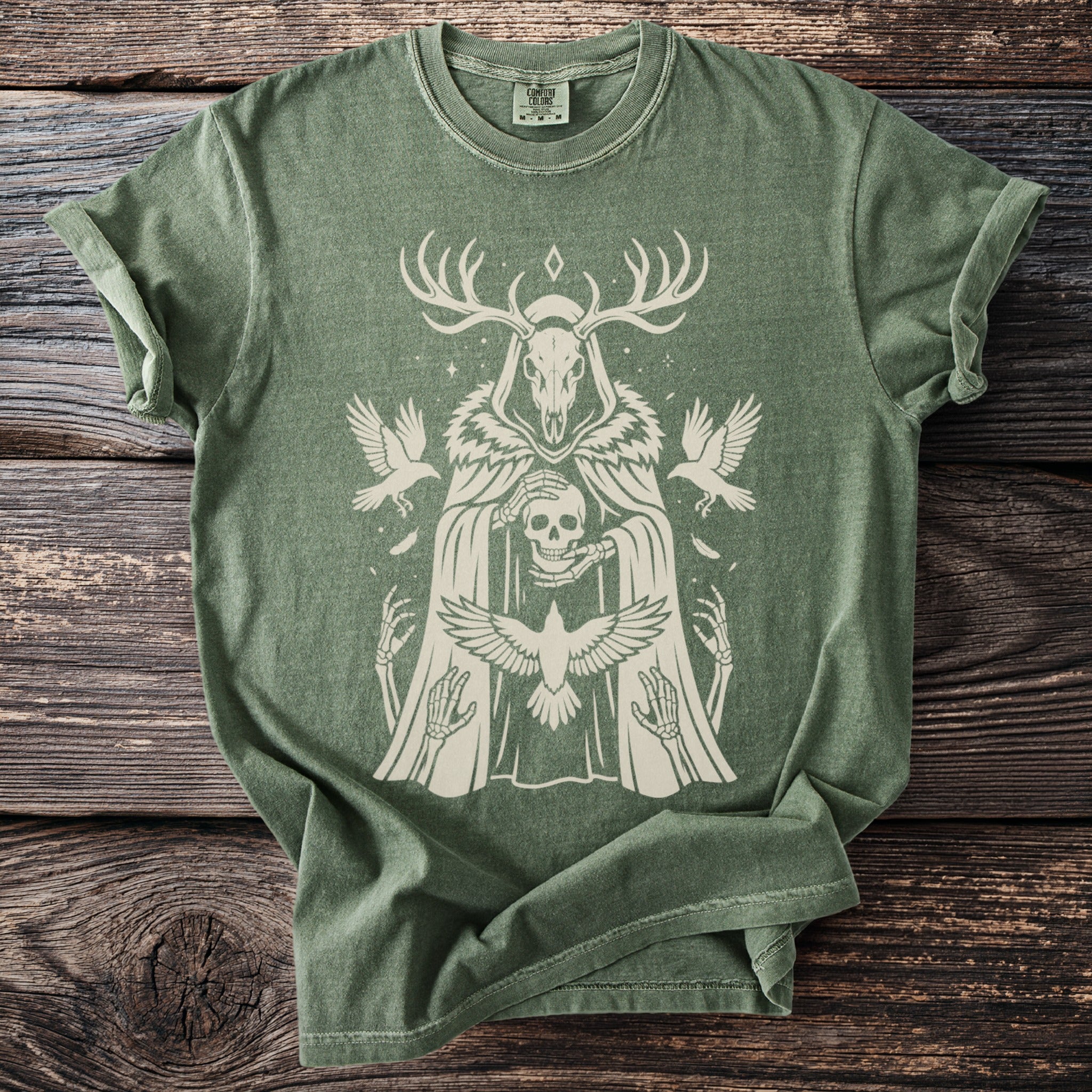 Green t-shirt with a beige distressed print of a skull-headed figure holding a skull.