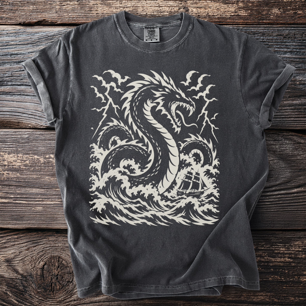 Dark grey t-shirt with a white graphic of a dragon and a sailing ship in stormy seas.