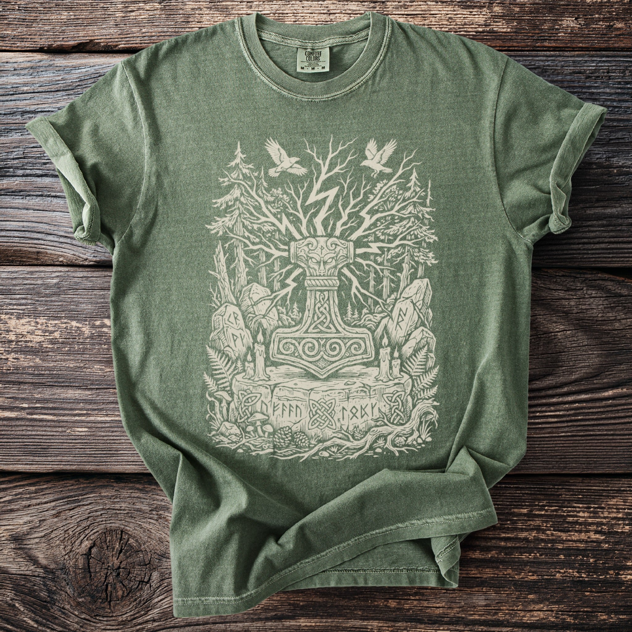 Green t-shirt featuring a Norse hammer design with trees, birds, runes, and candles.