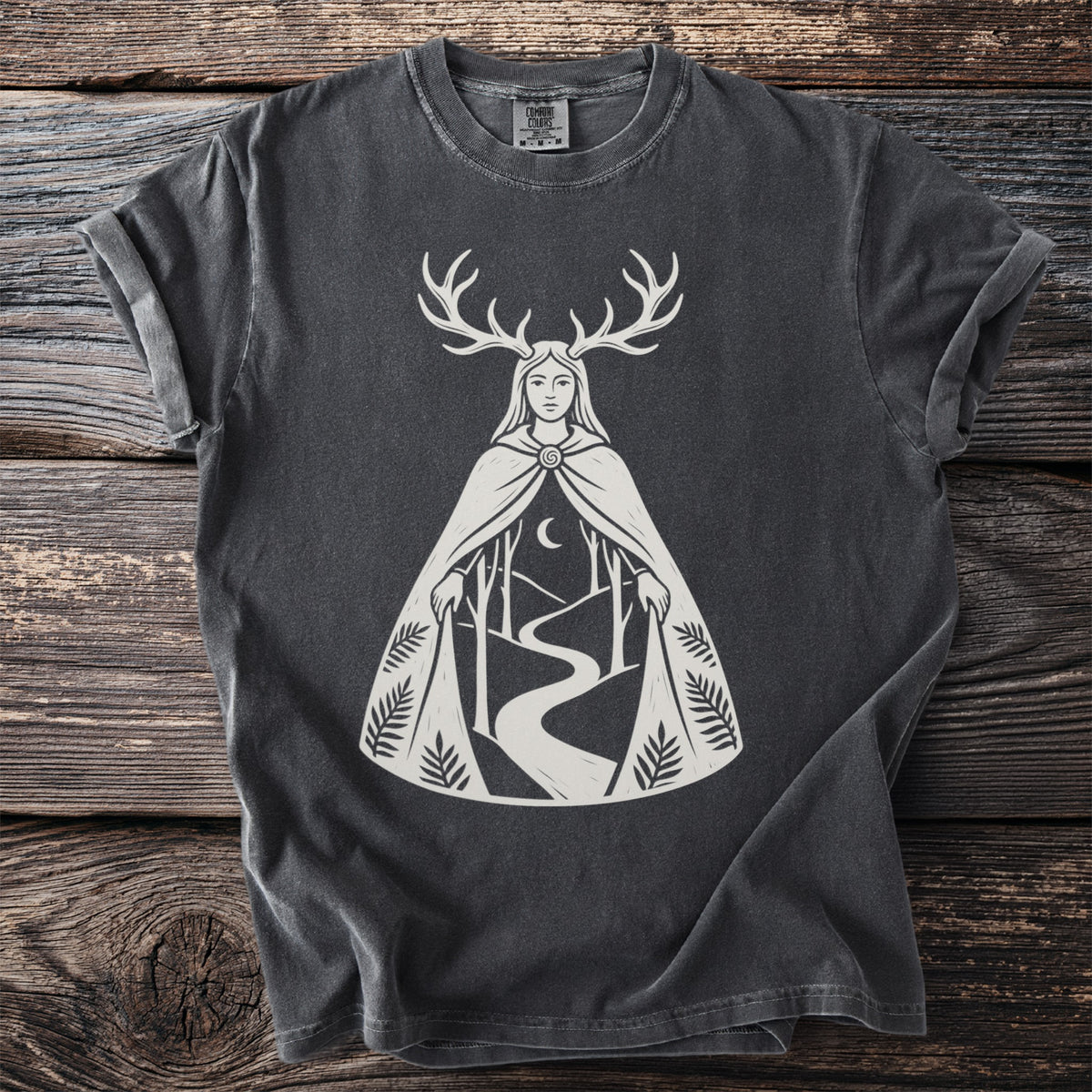 Dark grey t-shirt with a white graphic of a woman with antlers, a forest, and a moon.