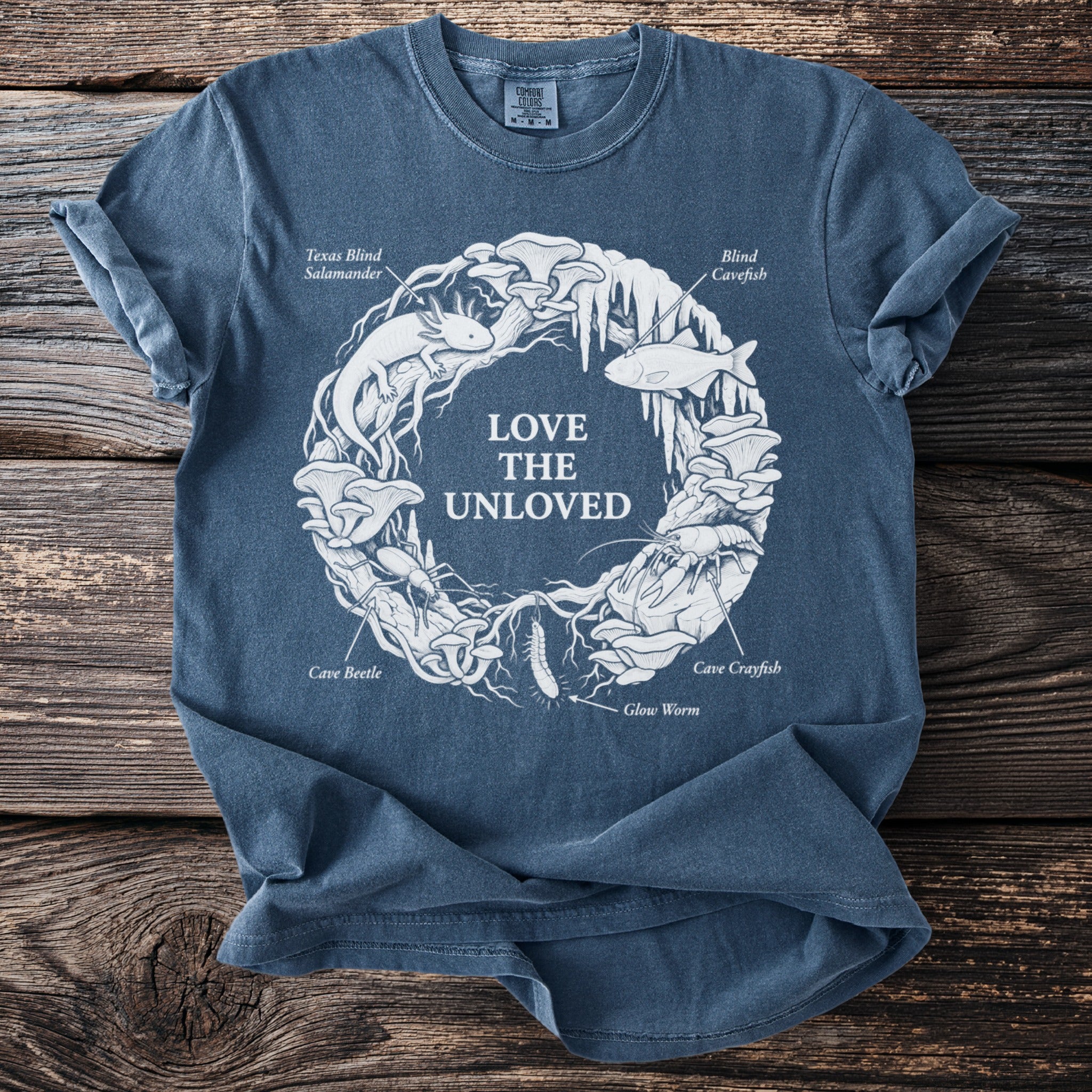 Dark blue t-shirt with "LOVE THE UNLOVED" and illustrations of cave creatures.