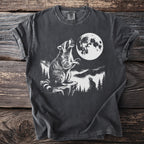 Graphic t-shirt with raccoon howling at full moon in mountainous forest scene.