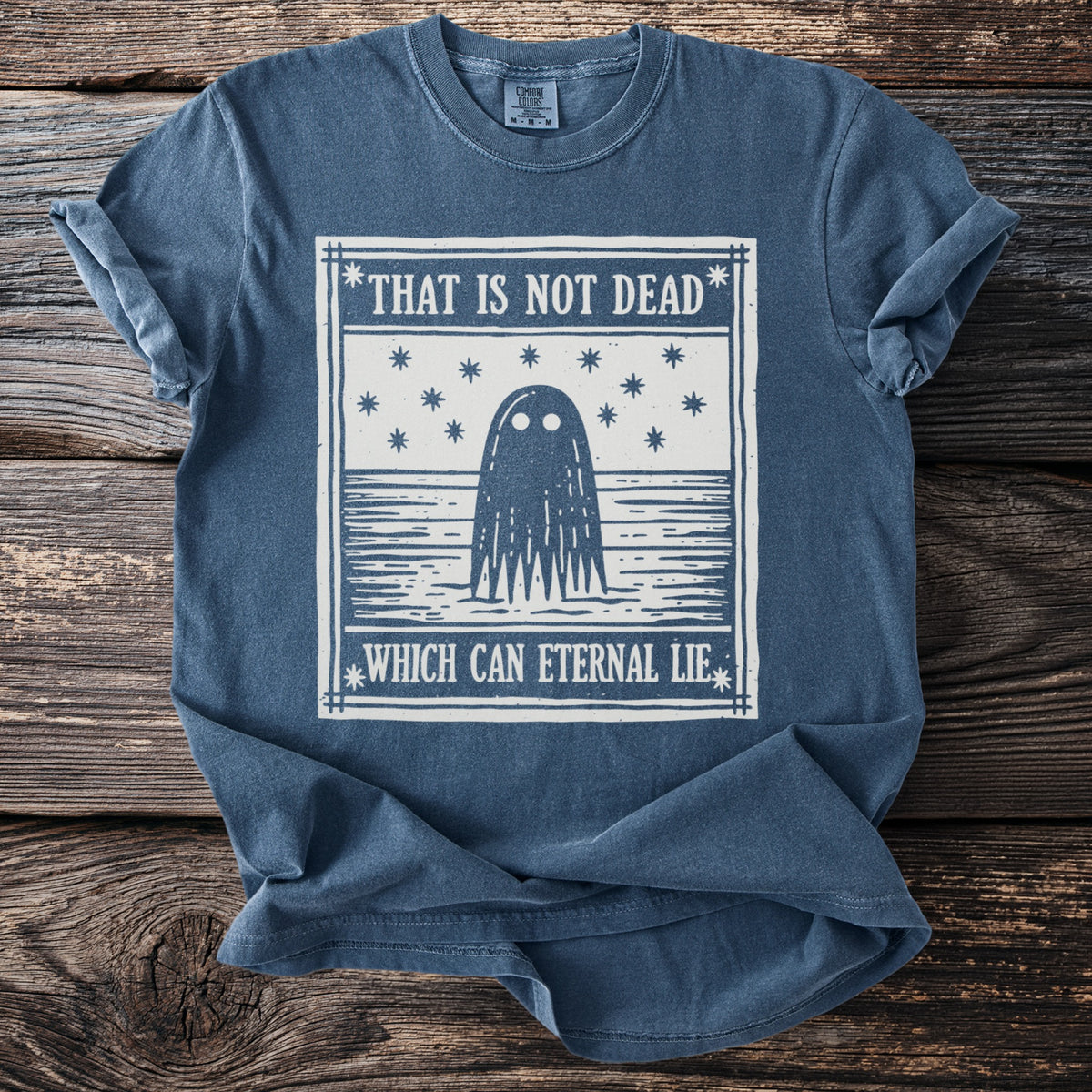 Blue t-shirt with a ghost design and text "THAT IS NOT DEAD WHICH CAN ETERNAL LIE".