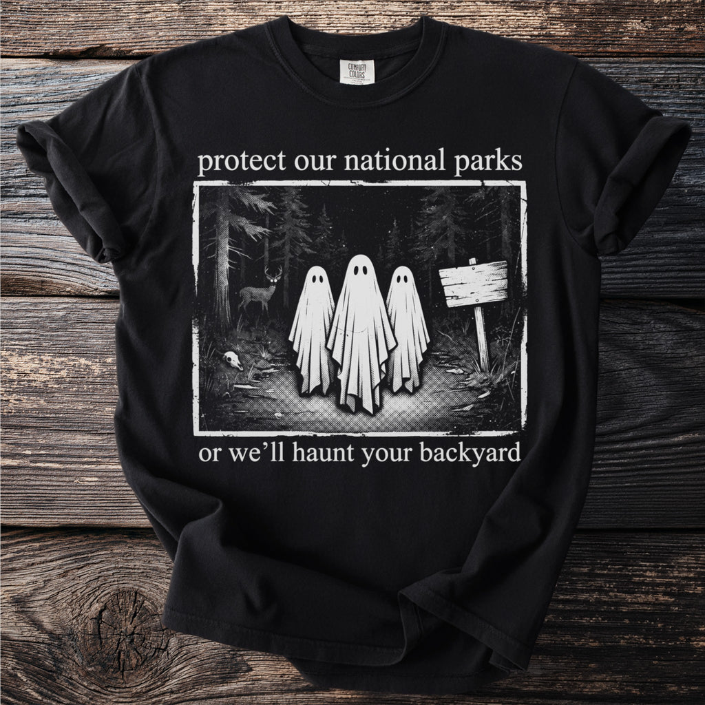 Black t-shirt with ghosts in a forest and text "protect our national parks or we'll haunt your backyard".