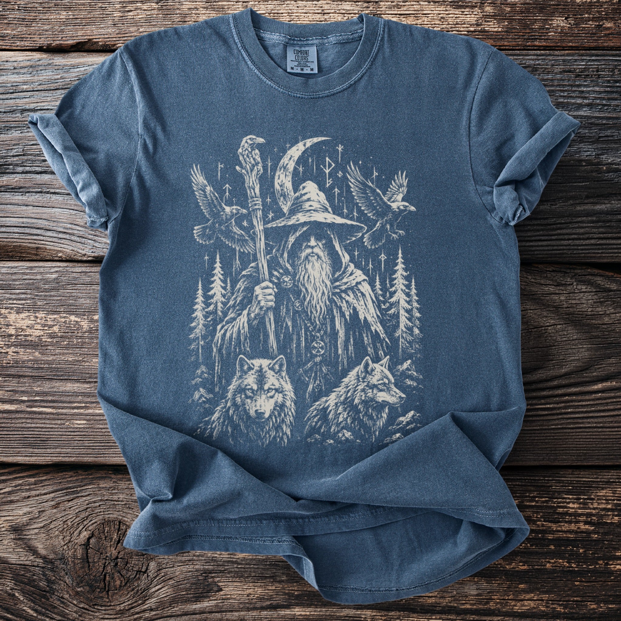 T-shirt with a graphic of a wizard, wolves, birds, trees, and Norse runes.