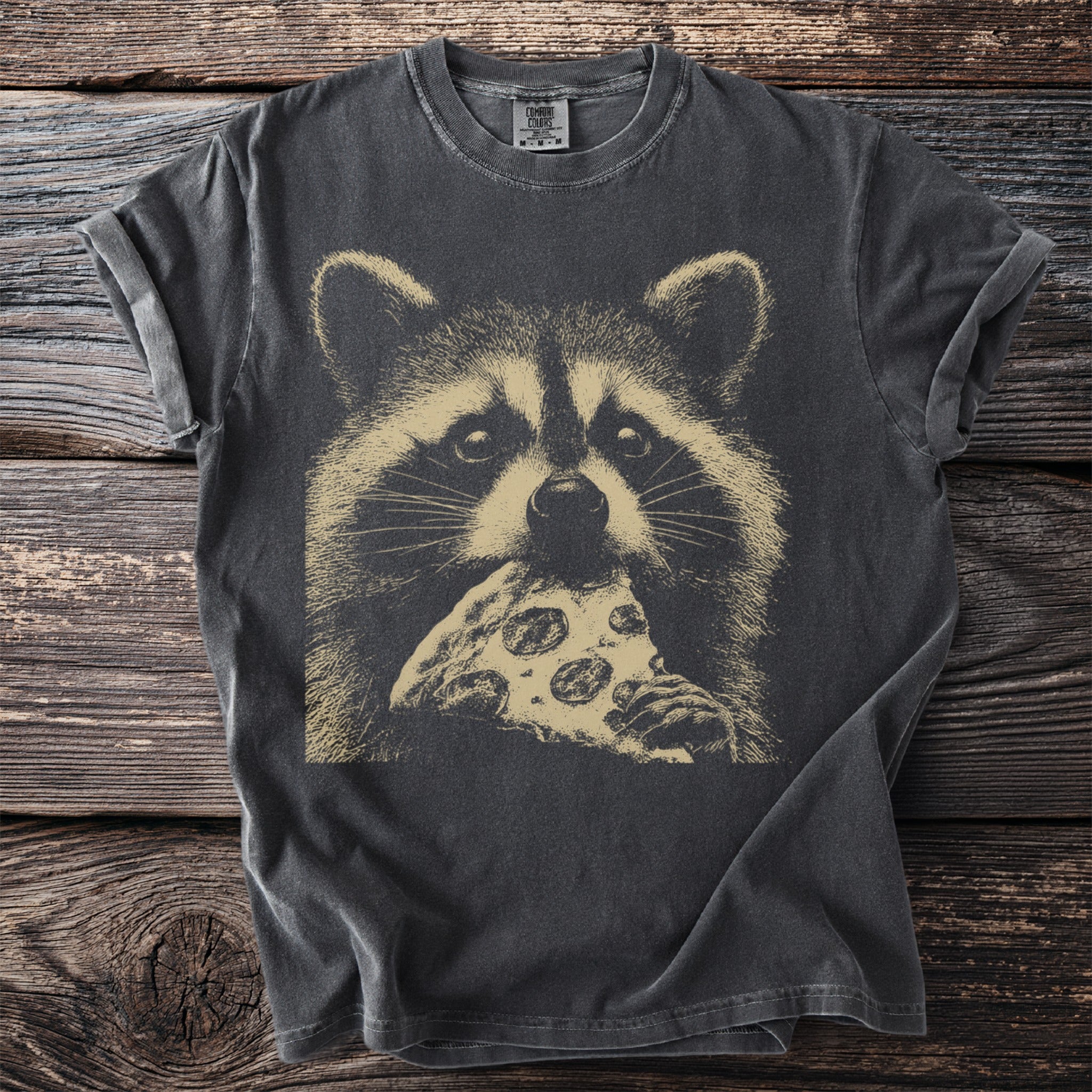 Dark t-shirt with a vintage print of a raccoon eating pizza.