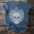 Blue t-shirt with white skull, floral, moth, and moon design.