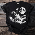 Black t-shirt with a graphic of two geese in a mountain landscape under a full moon.