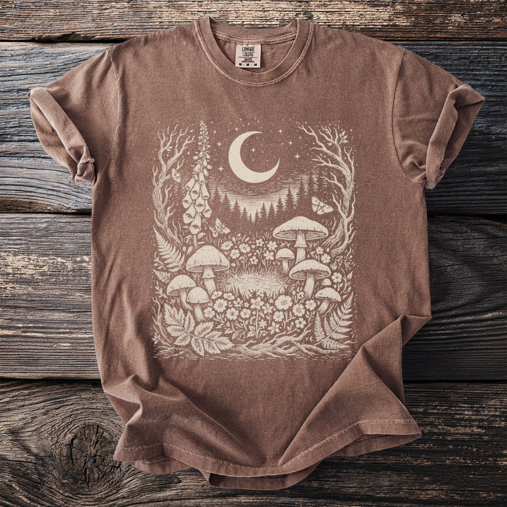 Brown t-shirt with an intricate cream graphic of mushrooms, flowers, a crescent moon, and stars.