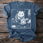 Opossum holding a bag of chips with the text "everything is technically edible."