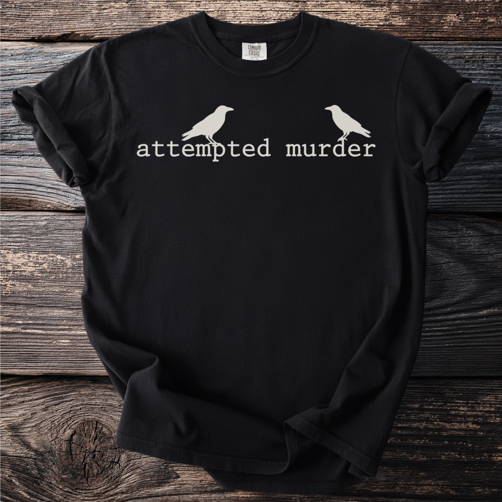 Black t-shirt with white text "attempted murder" and two crow graphics.
